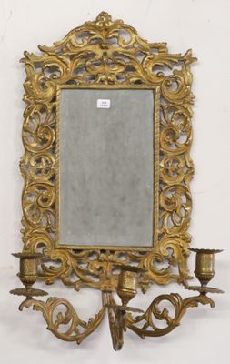 an image of a gold framed mirror on a wall next to a candelier