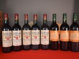 six bottles of wine are lined up on a red table