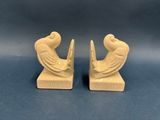 pair of carved wood bookends of a man and a woman sitting on a bench