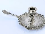 a silver plate with a candle holder on top of it
