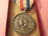 une médaille dans une boîte, entourée d'un ruban