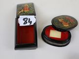 a small black box with a red lid and a small black box with a red lid and a small black box with a red lid
