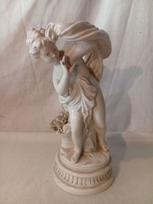 une statue représentant une femme tenant un panier de fleurs