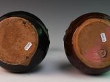 two brown and black vases sitting on top of a white table