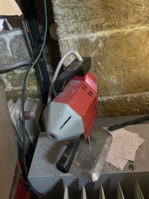 a red and white electric driller sitting on top of a table