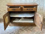 a wooden cabinet with two drawers and two pillows on it