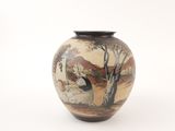 a vase with a painting on it sitting on a table