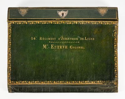 une boîte verte ornée d'une bordure dorée et d'une inscription