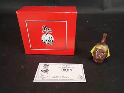 une petite figurine devant une boîte rouge