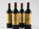 three bottles of red wine are lined up on a white surface