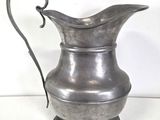 a silver pitcher that is sitting on a table