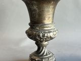 a silver vase that is sitting on a table