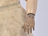 a doll that is wearing a dress and gloves