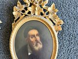 une vieille photo d'un homme barbu dans un cadre en or