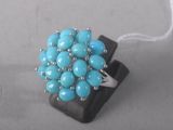 bague en perles turquoise agrémentée de perles argentées sur un fond noir