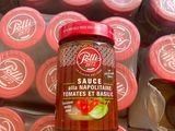 un pot de sauce posé sur une pile de tasses