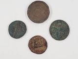 four ancient roman coins are shown in a row on a white surface