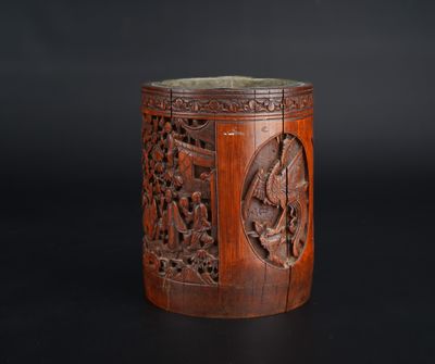un vieux vase en bois orné de sculptures sur un fond noir
