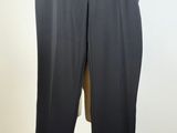 a black pants on a mannequin stand with a green sweater