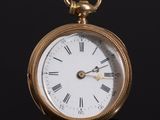 a gold pocket watch with roman numerals on the face