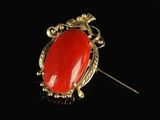 a gold and red stone broochle pin