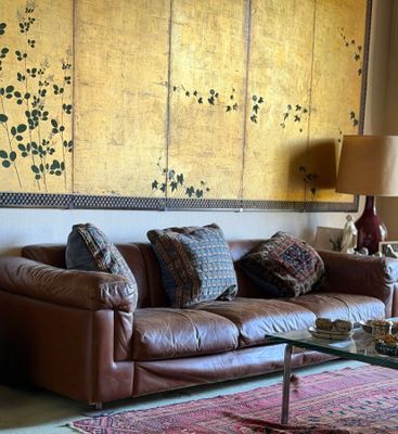 a living room with a leather couch and a large screen