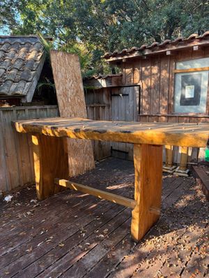 une table en bois sur une terrasse en bois devant une maison