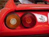 a close up of a red sports car with a sticker on it