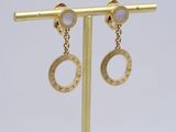 a pair of gold earrings with white stones on a gold stand