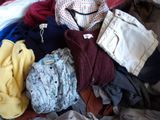 une pile de vêtements posée sur un lit