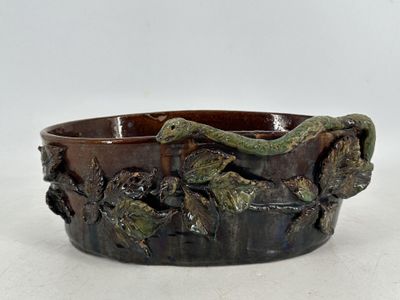un bol orné d'un serpent, posé sur une table