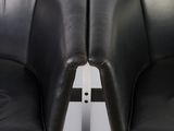 pair of black leather chairs with chrome legs against a white wall