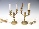 pair of antique brass candlesticks with white candles on them