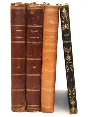 trois vieux livres sont empilés sur une surface blanche