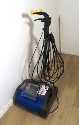 a vacuum that is sitting on the floor next to a wall