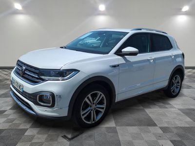 a white volkswagen suv is parked in a room with a checkered floor