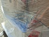 a large pile of boxes wrapped in plastic on the ground