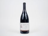 une bouteille de vin rouge posée sur une table blanche