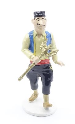 figurine of a man with a sword and hat on a white surface