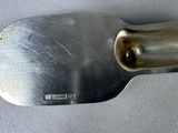 a metal spatula with a metal handle on a table