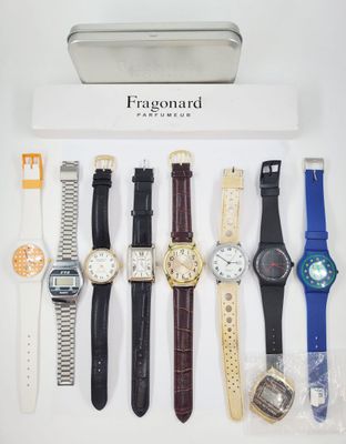 several watches are displayed in a display case on a white surface