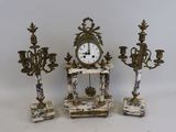 trois bougies et une horloge posées sur une table