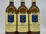 trois bouteilles de vin posées sur une table blanche