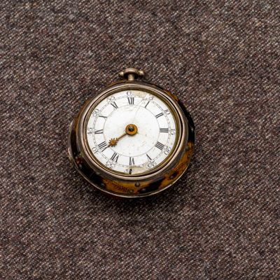 une petite montre de poche ornée de chiffres romains