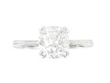 une bague en or blanc sertie d'un diamant taille coussin entouré de diamants
