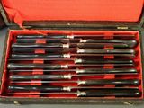 six knives in a case that are sitting on a table