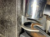 a close up of a coffee maker with a cup on it