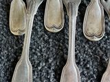 six fourchettes et cuillères en argent posées sur une table