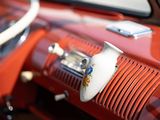a close up of a red car dashboard with a steering wheel