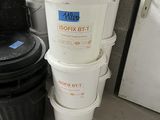 several buckets of food are stacked on top of each other in front of a refrigerator
